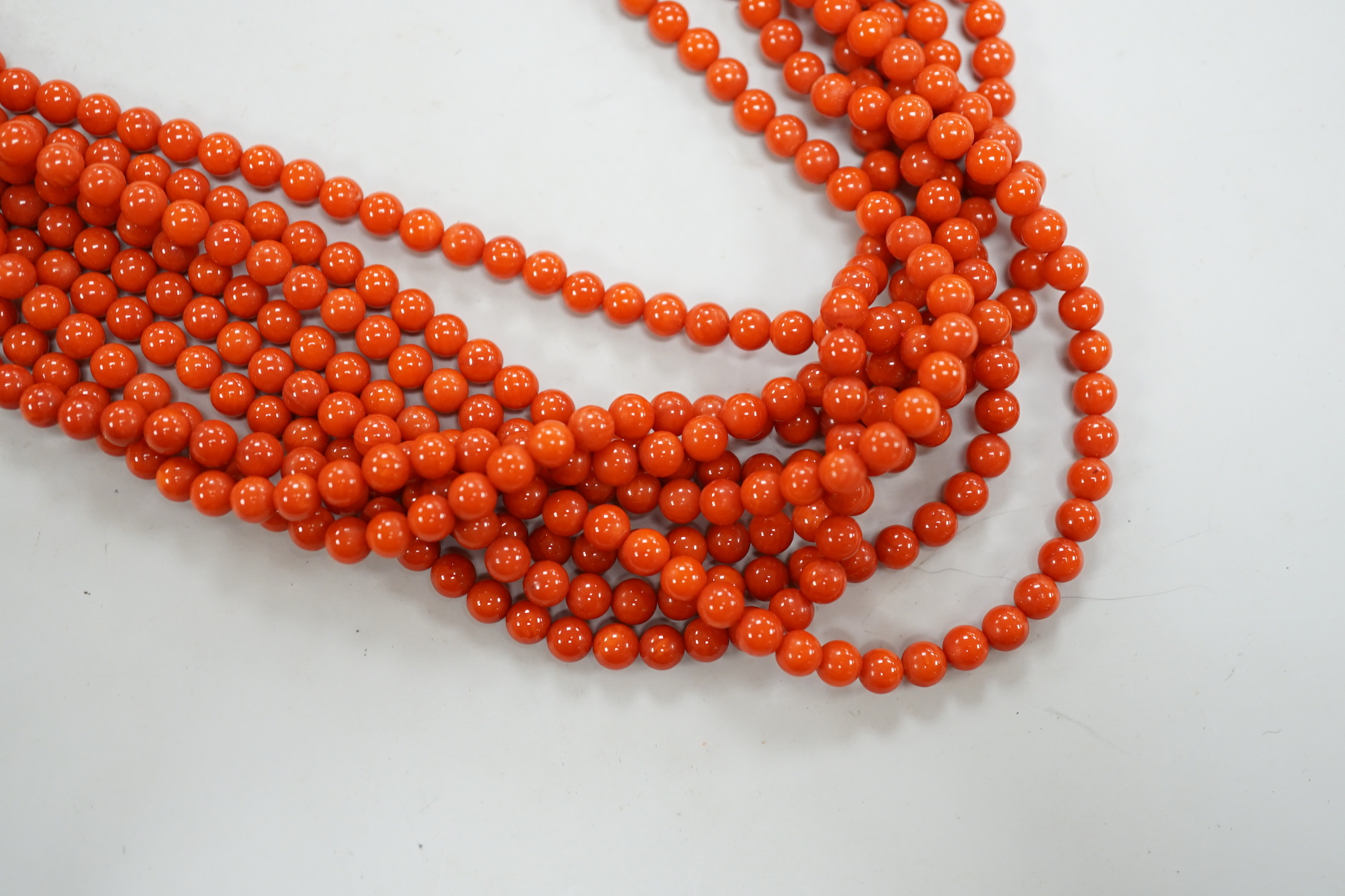 A 1980's Italian multi strand coral bead necklace, with 750 yellow metal clasp and Certificate of Authenticity, 50cm.